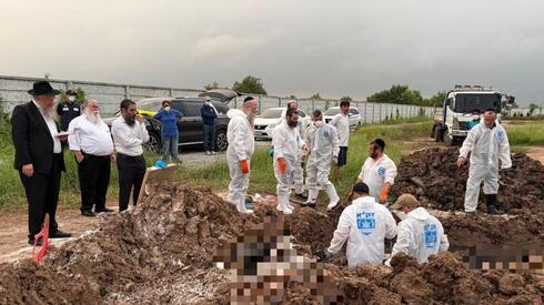 Workers and religious observers around a cemetery excavation